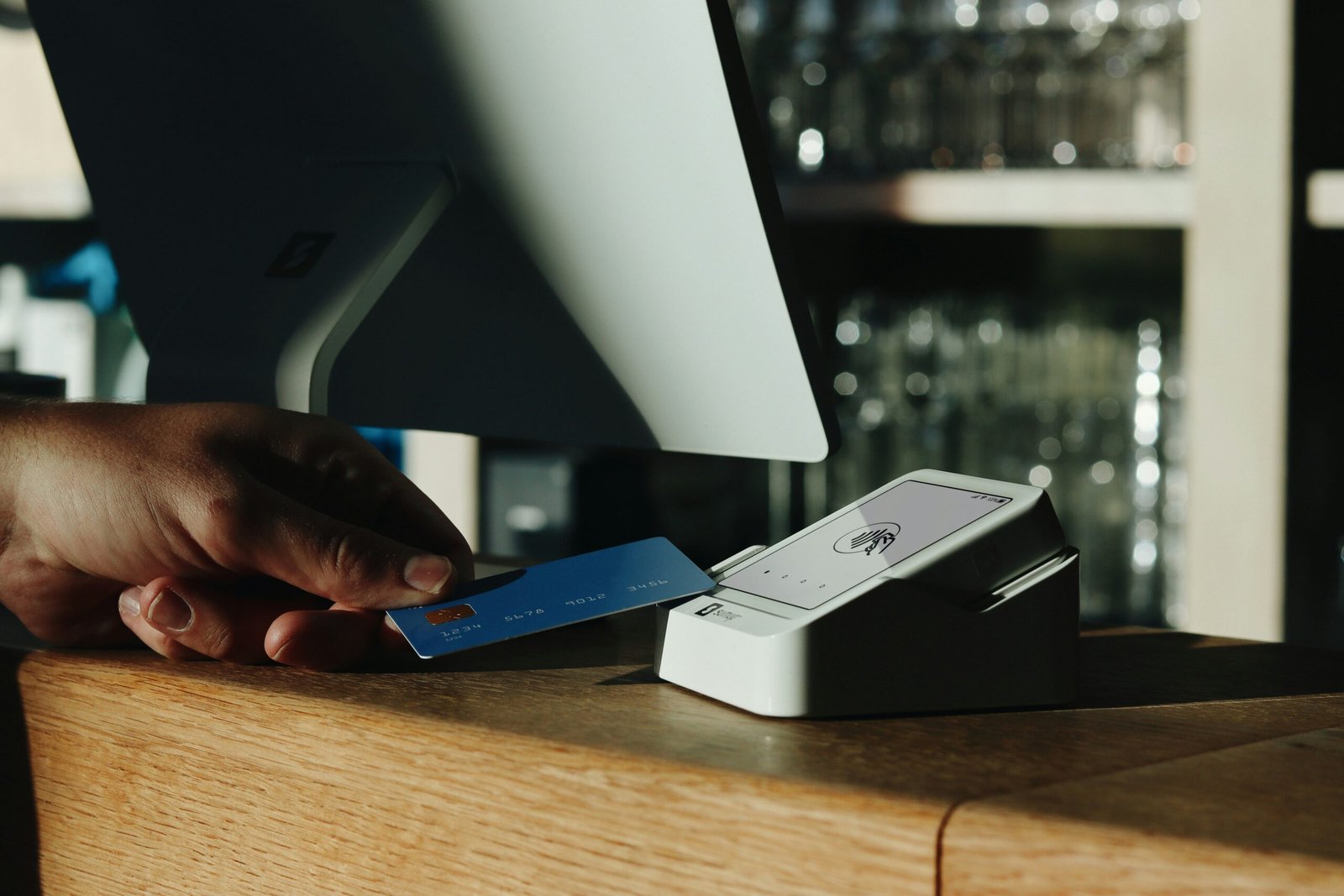 A sleek metal credit card placed beside a smartphone displaying a login screen requiring two-factor authentication.
