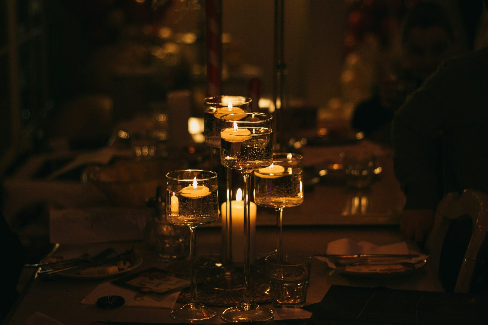 An elegantly set table with candles, wine glasses, and gourmet dishes.