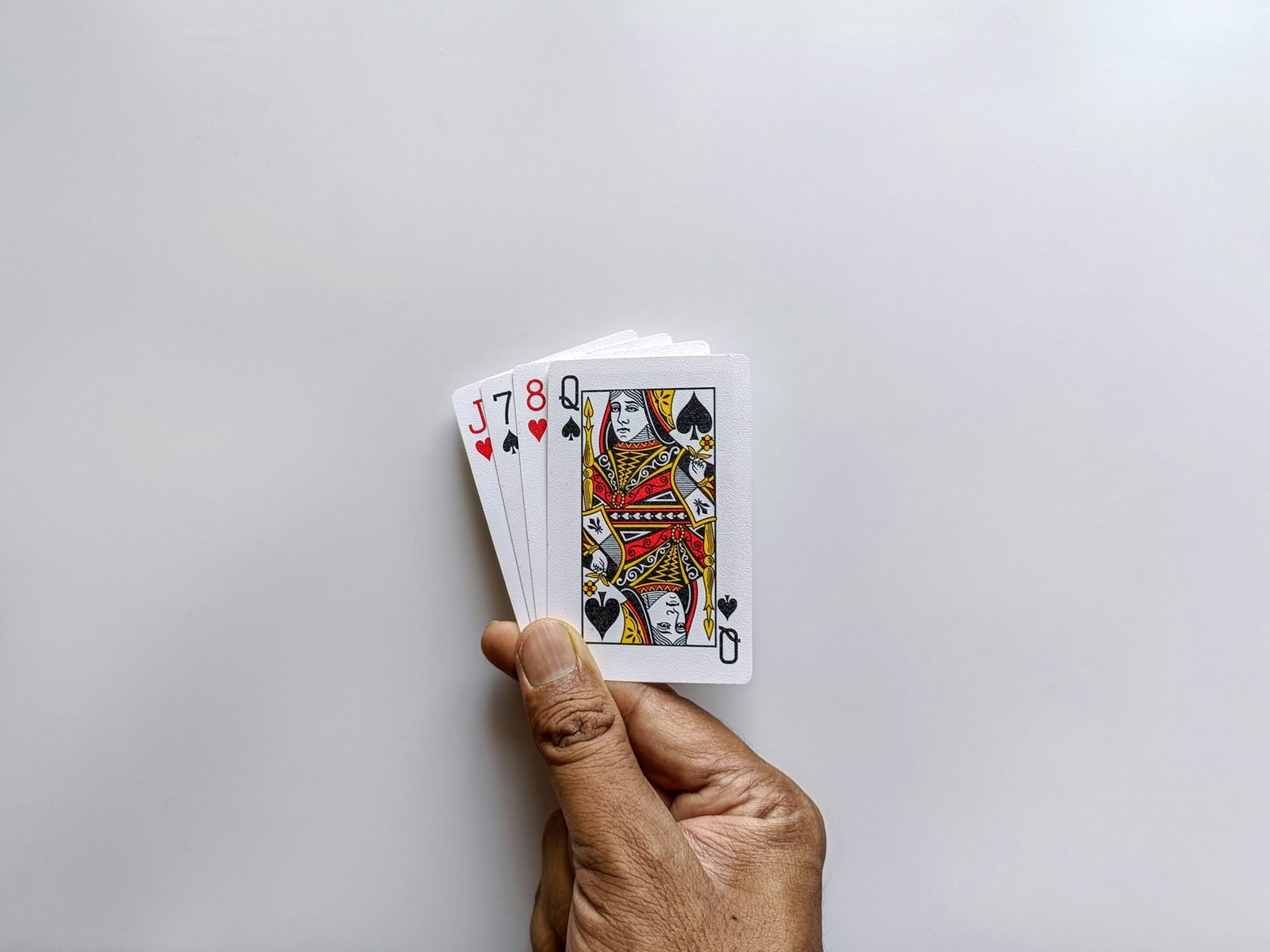 Hand holding a small stack of playing cards.